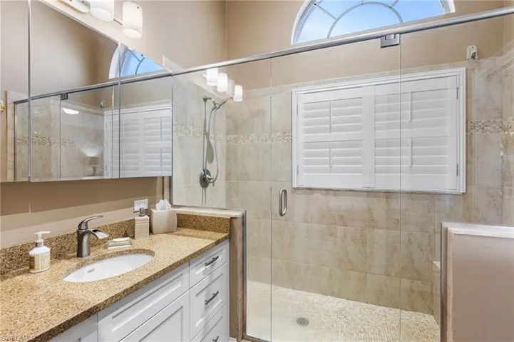 Bathroom featuring vanity and a shower stall