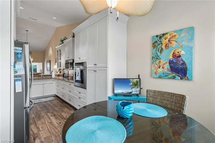 Dining space featuring dark wood-style flooring and high vaulted ceiling