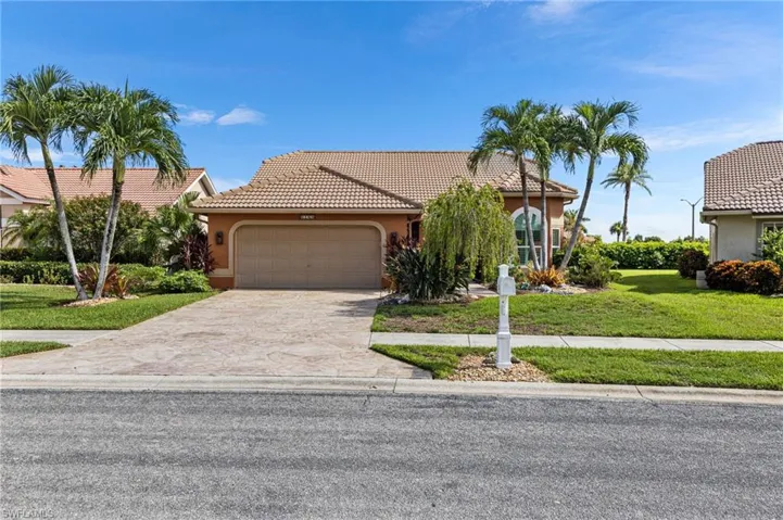 Mediterranean / spanish home featuring stucco siding, an attached garage, a front yard, concrete driveway, and a tiled roof