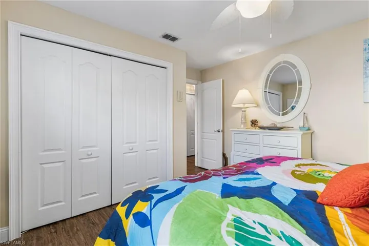 Bedroom featuring a closet, dark wood finished floors, and ceiling fan