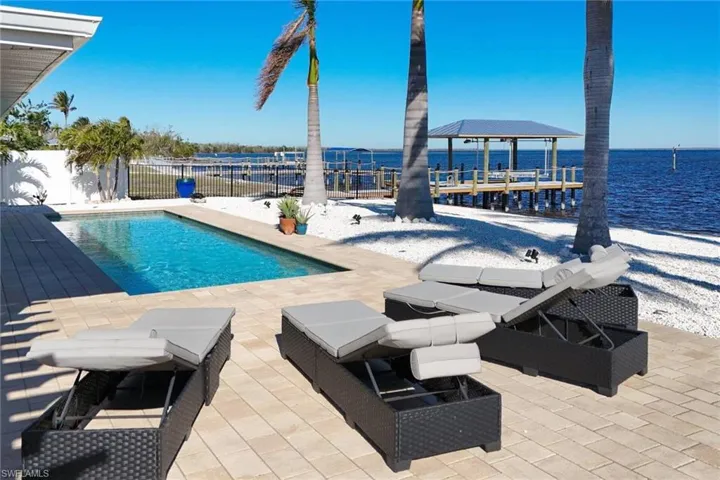 Another pool view with partial privacy fence - neighbor's home under renovation but dock & canopy recently completed.