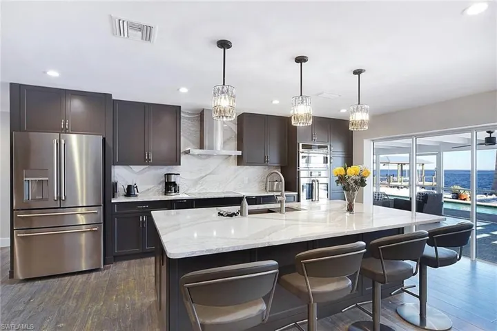 Kitchen and lanai with that water view! The gorgeous Bay View is enhanced by the pocketing triple glass sliders!