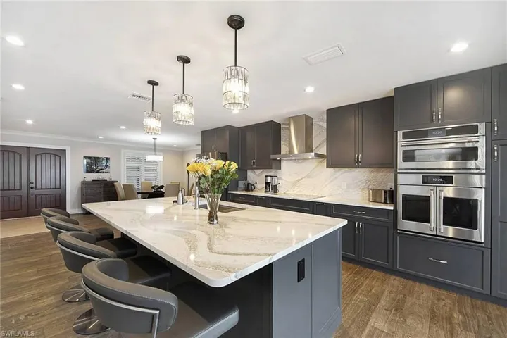 View to full kitchen, foyer, and dining