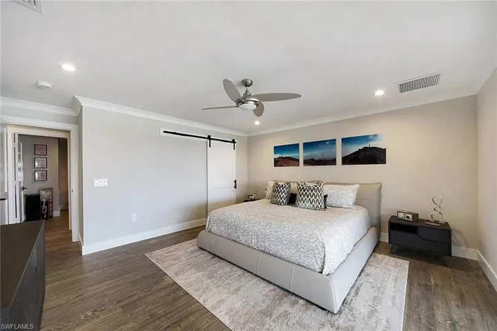 Primary bedroom with barn door to custom California closet