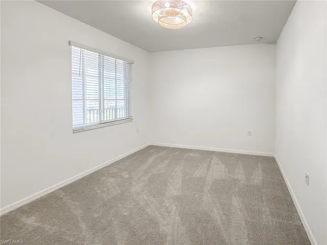 Empty room featuring carpet floors and baseboards