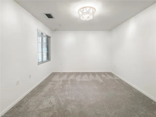 Unfurnished room with carpet flooring and baseboards