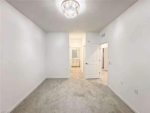 Empty room featuring light colored carpet and baseboards