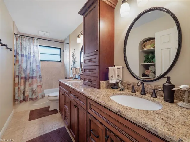 Full bathroom with vanity, toilet, and shower / bathtub combination with curtain