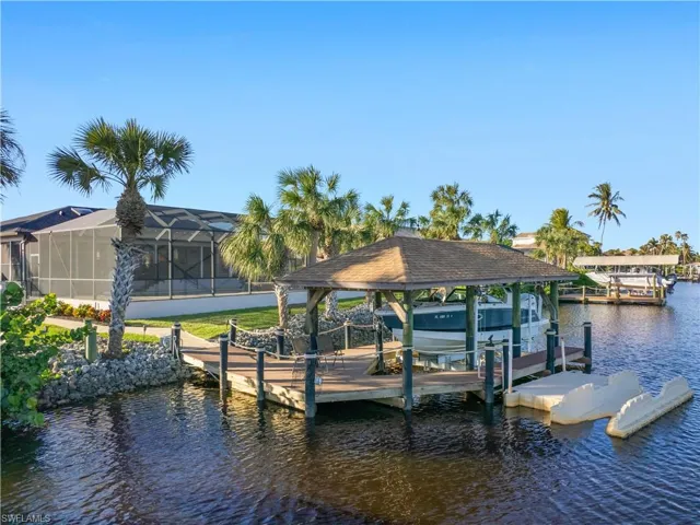 Dock area with a lanai and a water view