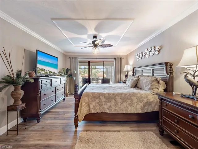 Bedroom featuring ceiling fan, access to exterior, wood-type flooring, and crown molding