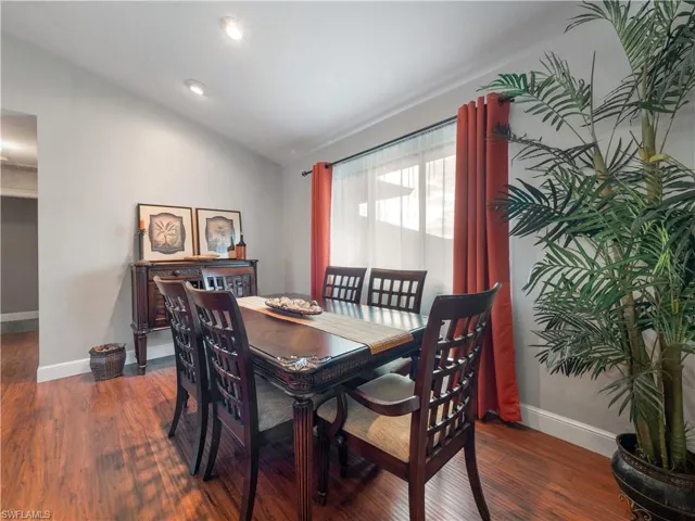 Dining space with dark hardwood / wood-style flooring and lofted ceiling