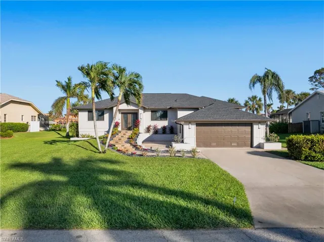 View of front of house with a front yard and a garage