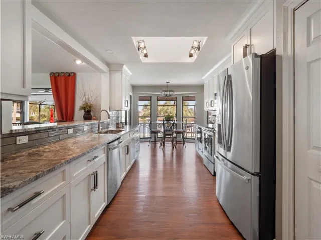 Kitchen featuring white cabinets, appliances with stainless steel finishes, and plenty of natural light