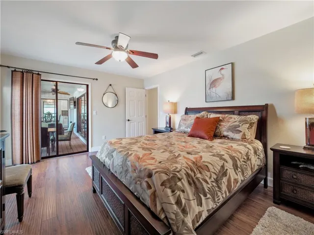 Bedroom with access to exterior, ceiling fan, and dark hardwood / wood-style floors