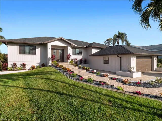View of front facade featuring a garage and a front yard