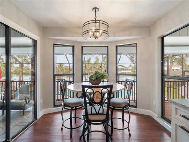 Dining space with dark hardwood / wood-style floors and a notable chandelier