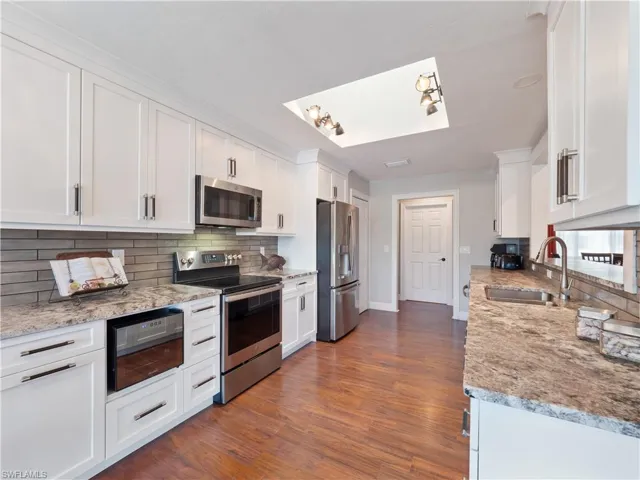 Kitchen with white cabinets, stainless steel appliances, and sink