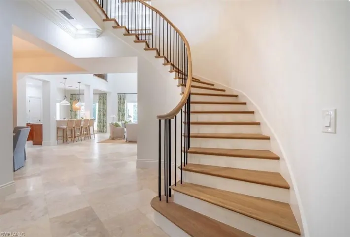 Stairway featuring crown molding and a high ceiling
