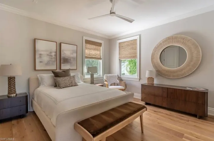 Bedroom with crown molding, light wood-style flooring, and a ceiling fan