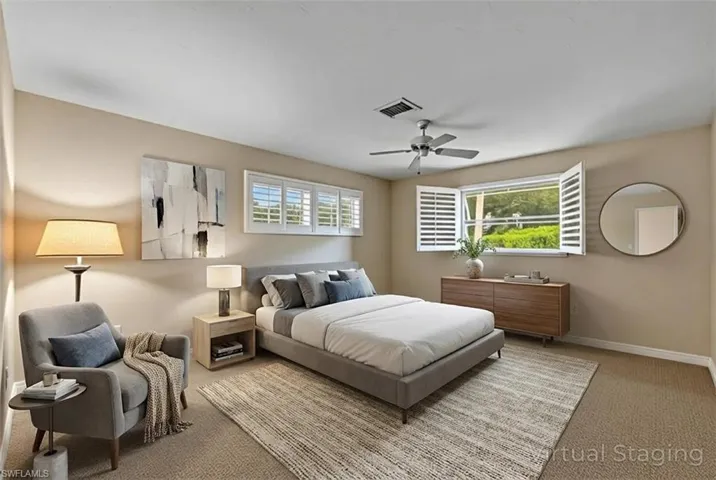 Carpeted bedroom with multiple windows and ceiling fan