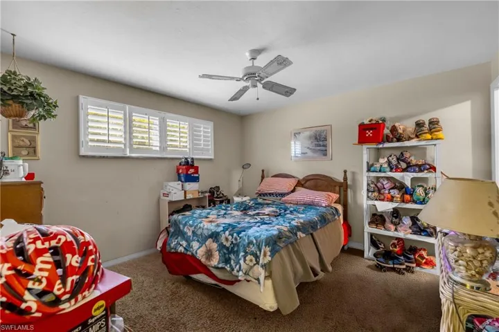 Carpeted bedroom featuring baseboards and ceiling fan