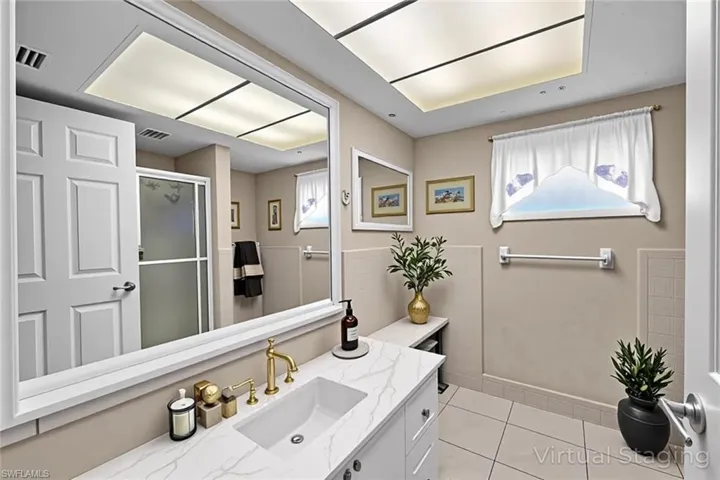 Bathroom featuring a stall shower, vanity, and light tile patterned floors