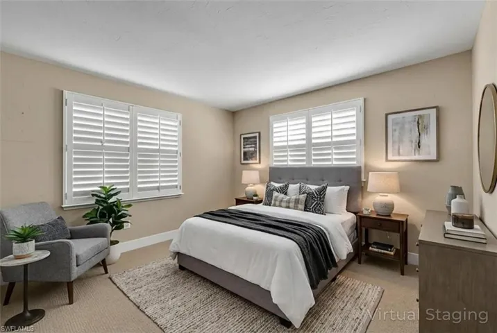 Bedroom with light colored carpet and baseboards