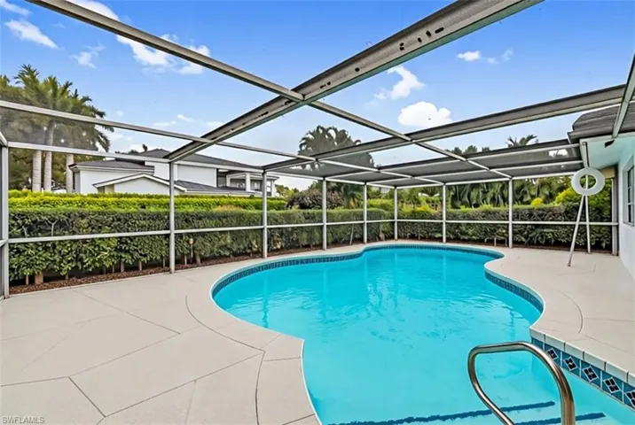 View of swimming pool with a sunroom, patio surround, and glass enclosure