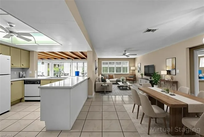 Kitchen with ceiling fan, light countertops, white appliances, and a peninsula