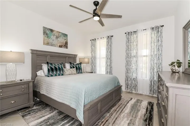 Bedroom with light tile patterned floors and ceiling fan