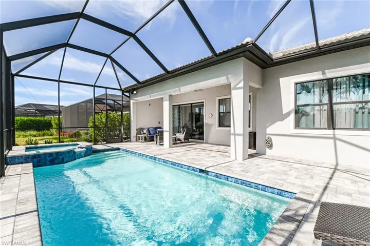 View of pool with a sunroom, a patio, a pool with connected hot tub, and a lanai