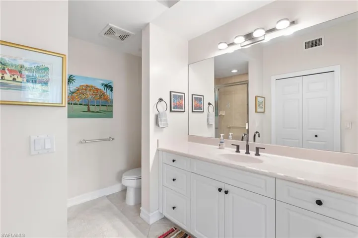 Full bath with tile patterned floors, vanity, a shower stall, and visible vents
