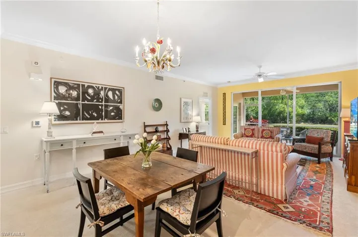 Dining room with ornamental molding, ceiling fan with notable chandelier, and baseboards