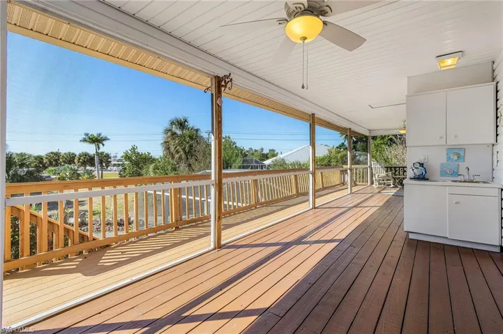 Large screened lanai with dual ceiling fans and a wet bar.
