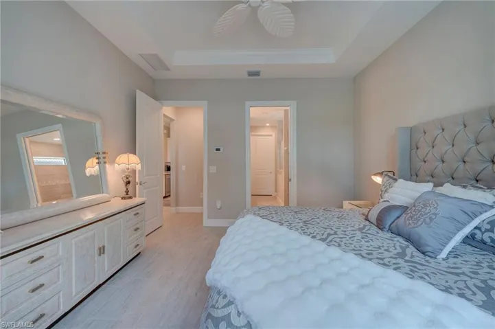 Bedroom with ceiling fan and a tray ceiling