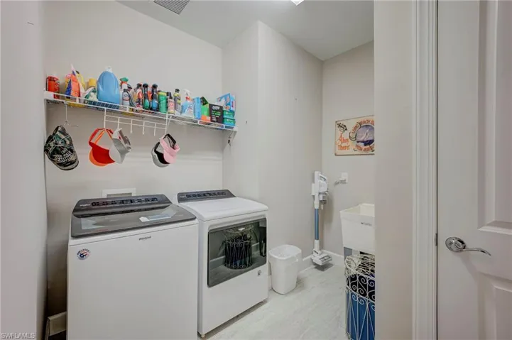Laundry area with washing machine and clothes dryer and light wood-style floors