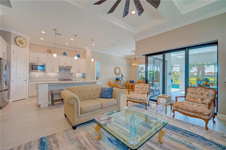 Living room with a ceiling fan, crown molding, and recessed lighting