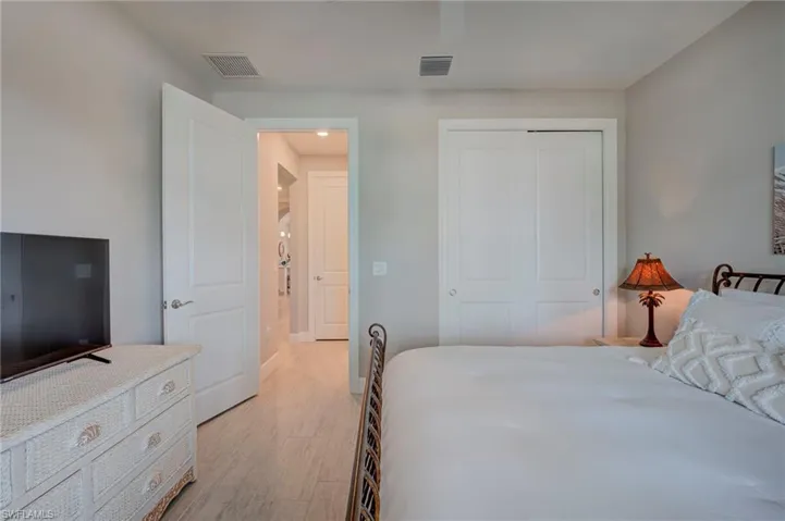 Bedroom with a closet, light wood-type flooring, and ceiling fan