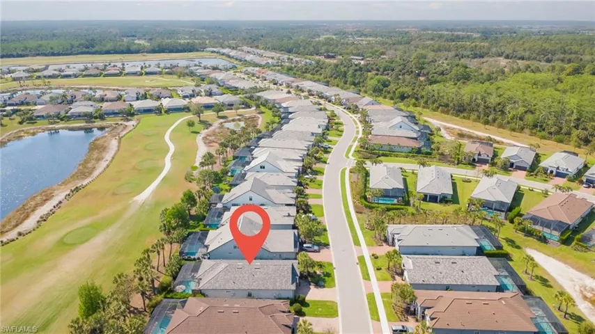 Aerial overview of property's location featuring nearby suburban area, a nearby body of water, and a golf club