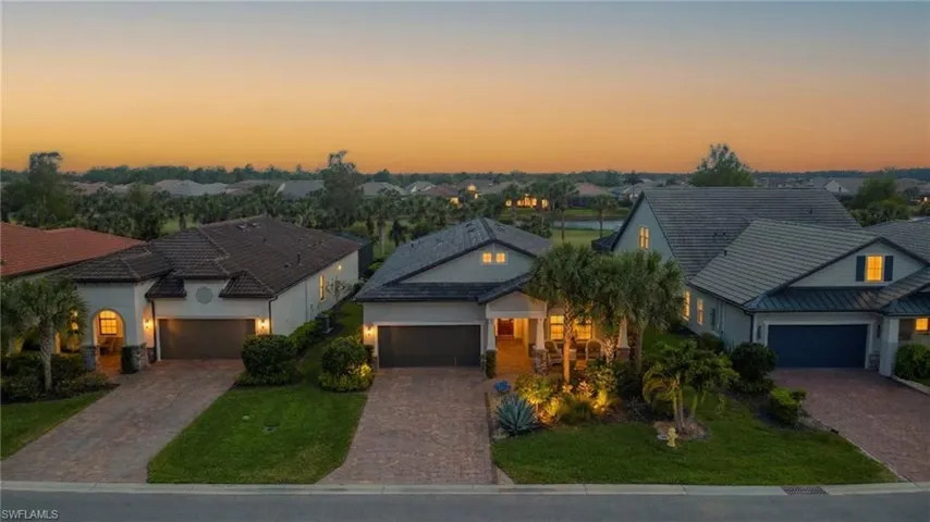 View of front of house featuring driveway, a yard, stucco siding, and an attached garage