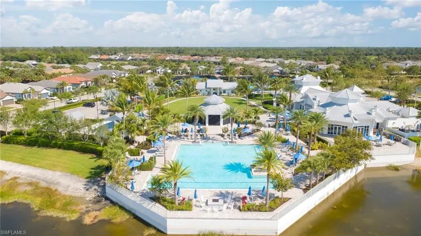 Aerial view of residential area featuring a nearby body of water and a pool area