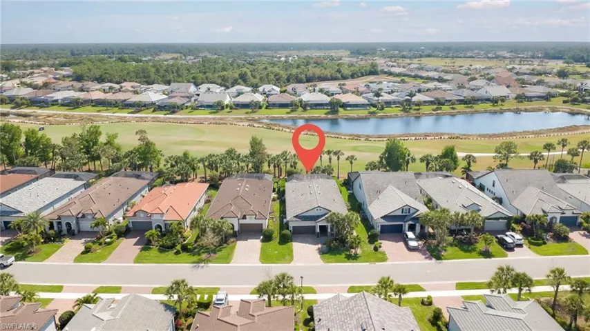 Aerial view of residential area featuring a nearby body of water and a local golf course