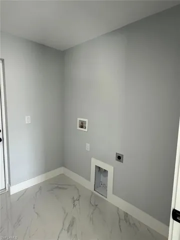 Laundry area featuring baseboards, hookup for an electric dryer, laundry area, washer hookup, and marble finish floor
