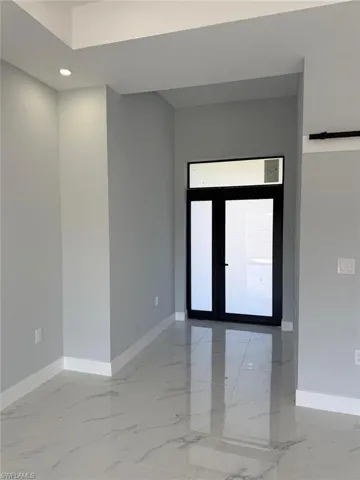 Unfurnished room with baseboards and marble finish floor