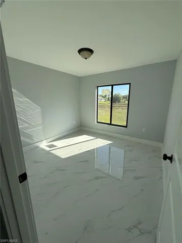 Spare room with baseboards and marble finish floor