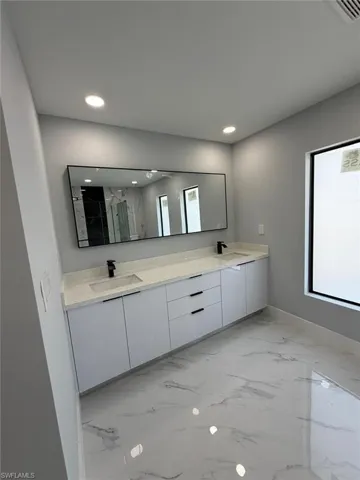 Full bathroom featuring a sink, a wealth of natural light, and double vanity