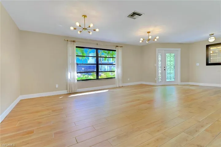 Spare room featuring a chandelier and light wood-style floors