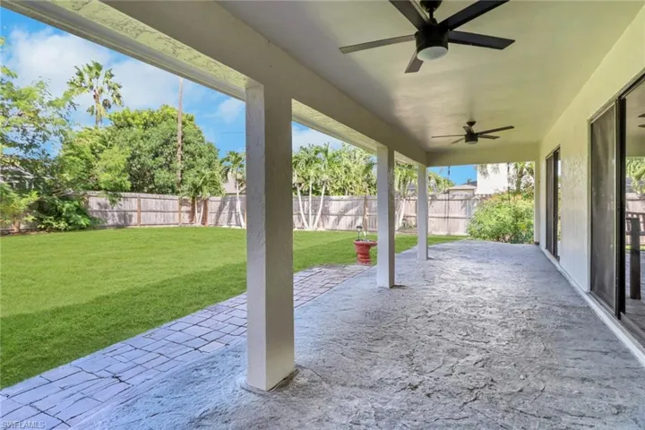 Fenced backyard featuring a patio area and ceiling fan