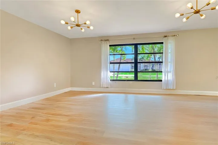 Empty room featuring a chandelier and light wood finished floors