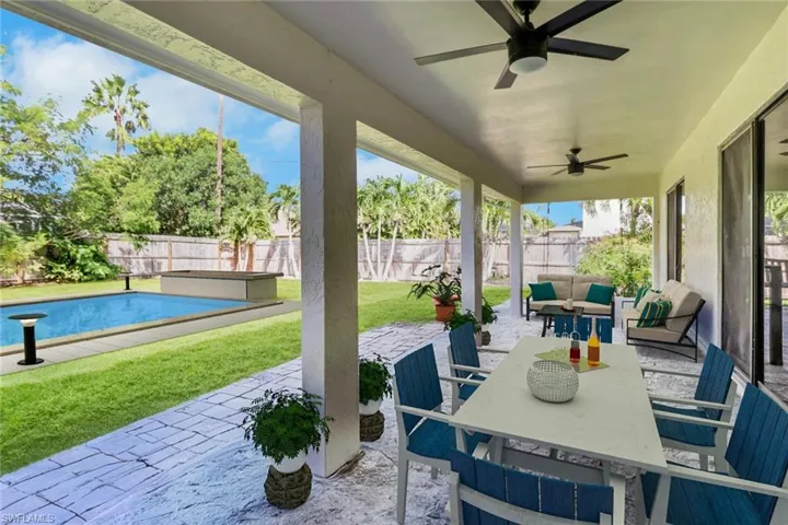 Fenced backyard with a patio area, outdoor dining space, ceiling fan, and an outdoor hangout area